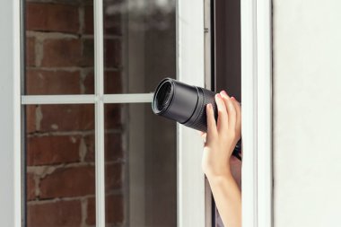 Gözetleme kameralı özel dedektif açık pencereden fotoğraf çekiyor. Kapatın. konsept.