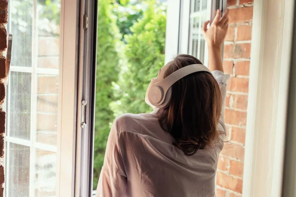 Jonge Mooie Gelukkige Vrouw Koptelefoon Luisteren Muziek Opent Venster Van — Stockfoto