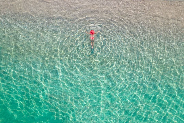 顶部视图 身穿红帽子和比基尼的年轻漂亮的女人躺在沙滩上 沐浴在海水中 无人机 复印机照片 从上面看 — 图库照片