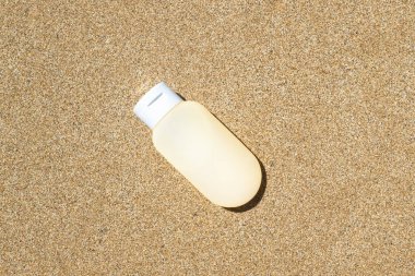 Kumsalda duran güneş kremi. Seyahat, tatil, yaz tatili konsepti. Uzayı kopyala Üst Manzara. Düz yatıyordu