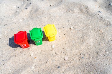 Kağıt, plastik, cam ve organik atık içeren farklı renkli çöp tenekeleri kumlu sahilde geri dönüşüm için uygundur. Atıkları ayır, çöpleri ayır. Üst görünüm