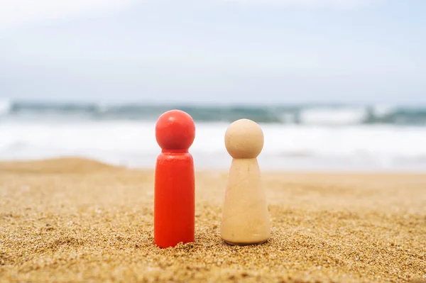 Wooden Two Figures Different Color People Red Dark White Sand — Stock Photo, Image