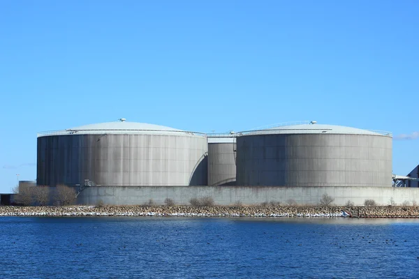 Contenedores de gas en planta energética con lago y cielo azul — Foto de Stock