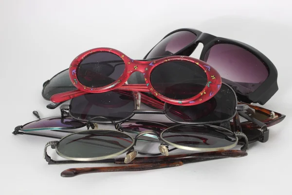 Pile of sunglasses with red pair on top - isolated — Stock Photo, Image