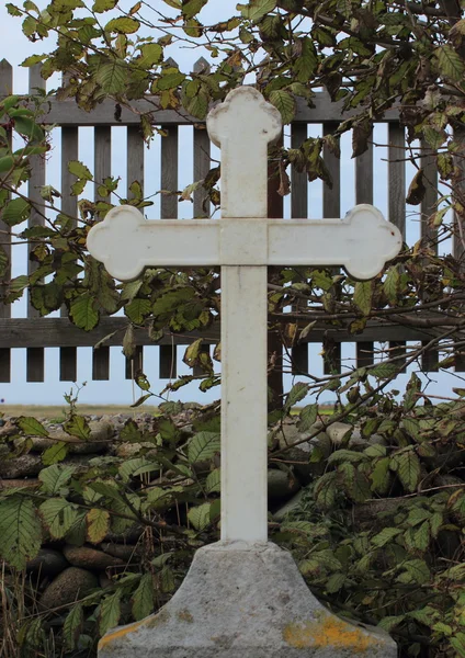 Old metal cross on top of headstone at graveyard — Stock Photo, Image