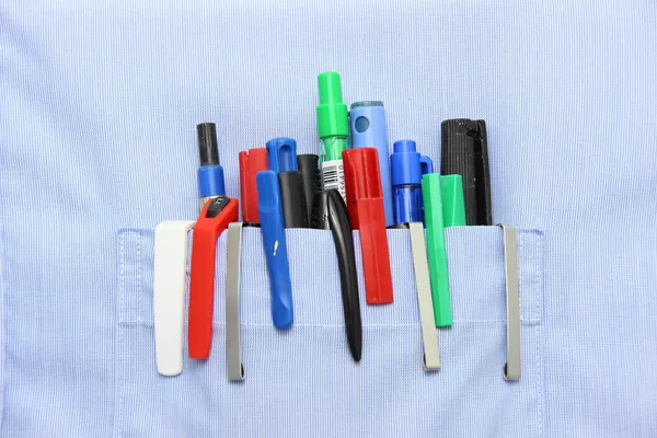 Blue shirt pocket with many different ballpoint pen — Stock Photo, Image