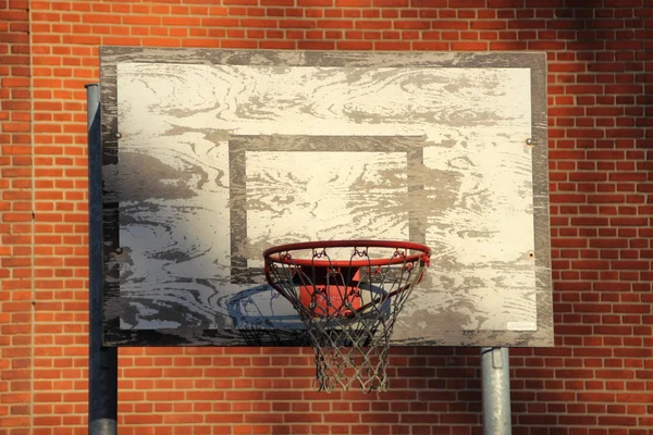 Red de baloncesto al aire libre vieja y desgastada con fondo de ladrillo rojo —  Fotos de Stock