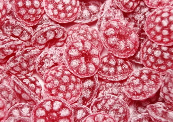 Montón de bombones rojos de frambuesa dulce con azúcar Imagen De Stock