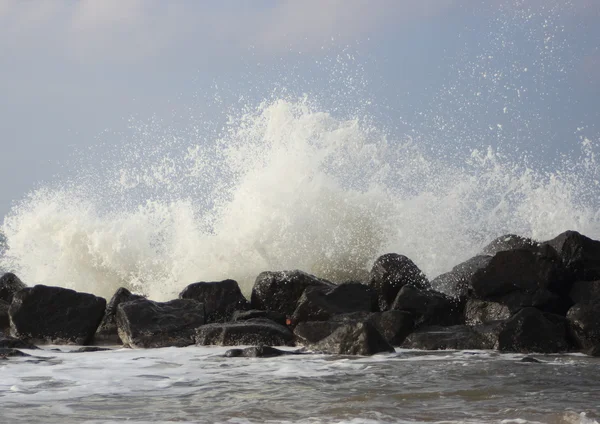 Onde d'urto contro rocce nere sulla costa — Foto Stock