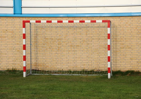 Objetivo de balonmano vacío al aire libre con pared en el fondo — Foto de Stock