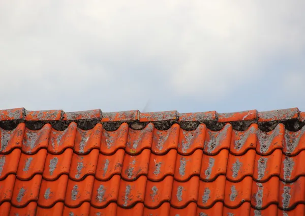 Tampo do telhado com azulejos vermelhos e nuvens — Fotografia de Stock