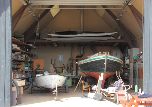 Binnen kleine schip workshop met twee boten onder reparatie Stockafbeelding