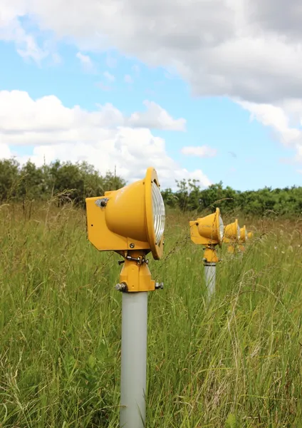 Closeup on runway landing lights in grass field — Stock Photo, Image