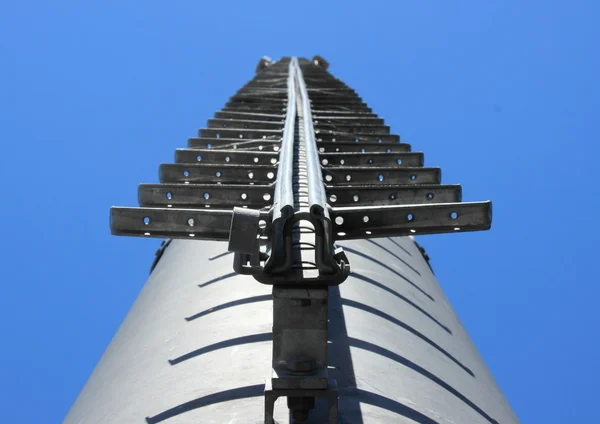 Металлическая лестница на дымоходе против голубого неба — стоковое фото