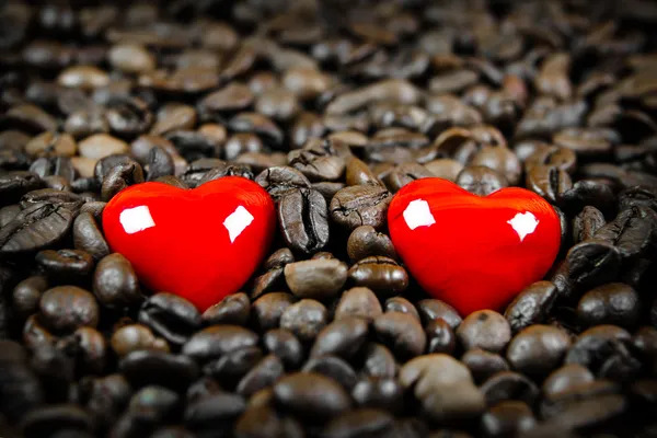 Två röda hjärtan i kaffebönor — Stockfoto