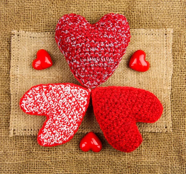 Knitting hearts on the sackcloth — Stock Photo, Image