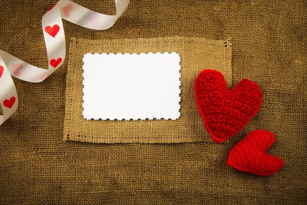 Knitting hearts on the sackcloth — Stock Photo, Image