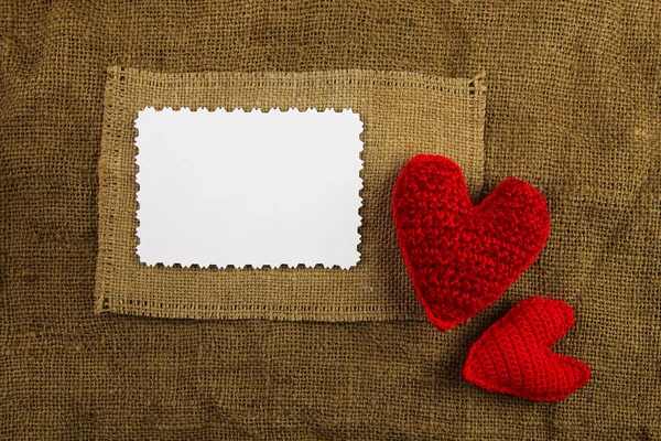 Knitting hearts on the sackcloth — Stock Photo, Image