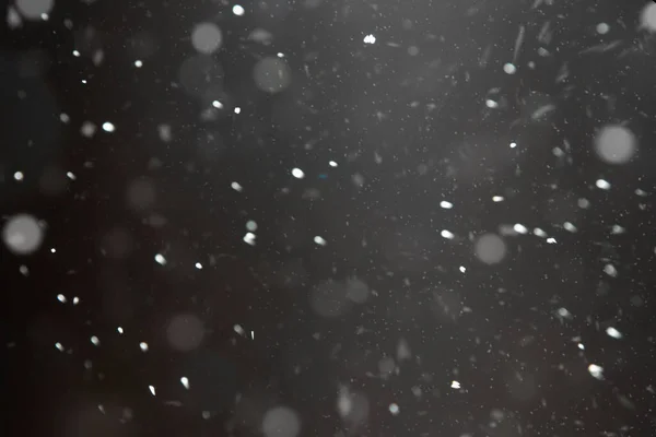 La neige tombe contre un ciel sombre dans la lumière. blizzard nocturne froid et neige. — Photo