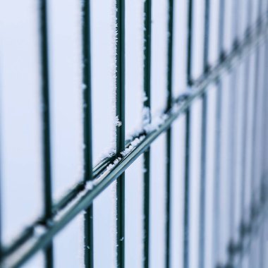 Kışın metal çitler. Çitlerde kar var. Karda eskrim. Arkaplan.