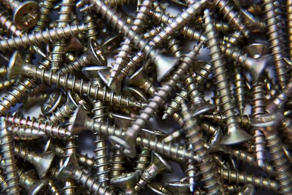 Üçlü vidalar, bir sürü. Yakın plan. Geçmişi ve dokuları. Ahşap üzerine inşaat malzemeleri. Fastener. Üst görünüm.