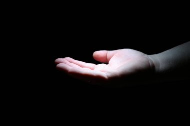  Karanlıktaki bir insanın avuç içi beyaz ışıkla aydınlanır. İzole et.