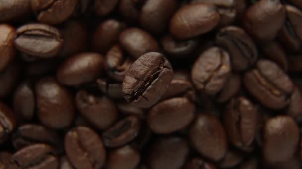 Chicchi di caffè in primo piano un grano ruota sullo sfondo di altri chicchi. — Video Stock