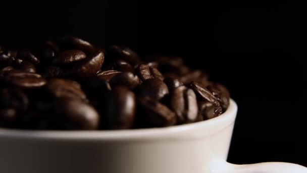 I chicchi di caffè in una tazza ruotano su uno sfondo nero. chicchi di caffè. — Video Stock