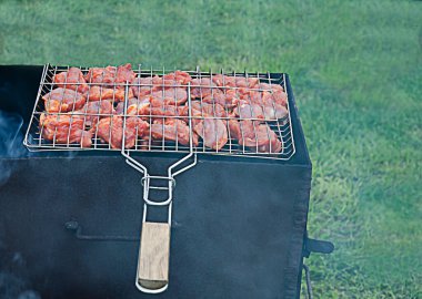 Şiş kebap, yeşil çimenlerin arka planında ateşte kızarır. Et pişti. 
