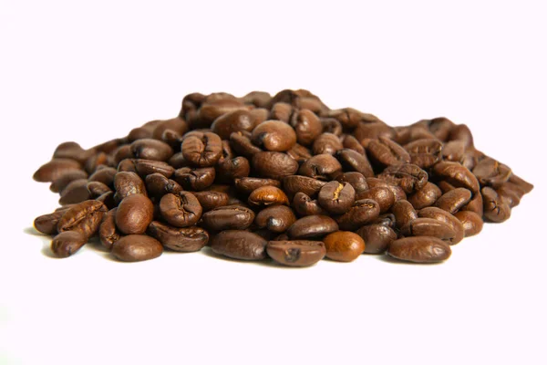 Ett gäng kaffebönor på nära håll. rostade kaffebönor på en lätt bakgrund — Stockfoto