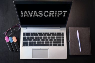 Javascript isimli dizüstü bilgisayarın üst görünümü. Dizüstü bilgisayarda ve klavyede JavaScript yazıları var. Programlama dili, bilgisayar dersleri, eğitim öğrenin. 