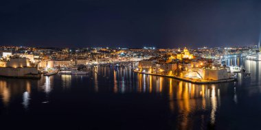 Geceleri Malta 'daki üç şehrin panoramik manzarası. Fotoğraf Valetta 'dan. Grand Harbour gece aydınlandı..