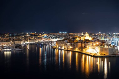 Geceleri Malta 'daki üç şehrin manzarası. Fotoğraf Valletta 'dan. Grand Harbour gece aydınlandı..