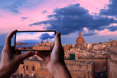 Valletta eski kasaba ve liman, Valletta, Malta üzerinde gün batımının fotoğrafını çeken bir turist..