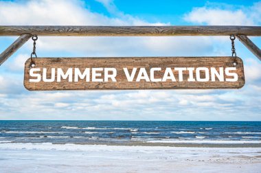Summer vacations wooden sign against blue sky and sea with waves background.