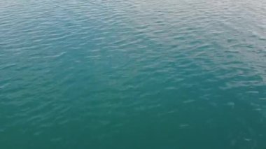 Drone view of beautiful seamless never ending footage while turquoise sea waves breaking on the sandy coastline. Aerial shot of golden beach meeting deep blue ocean water and foamy waves. 
