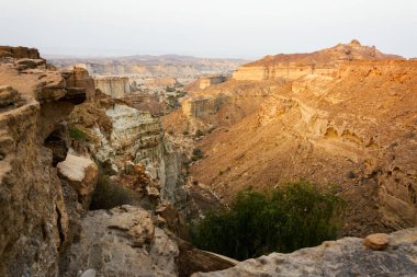 Gün batımında Chabahar 'da, Baluchistan' da masa üstü ya da düz tepeli dağlar. İran 'daki derin vadiler. Okyanusa yakın toprak erozyonu.