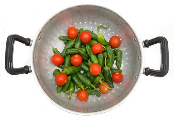 Tomates e pimentas verdes em uma tigela de metal Imagem De Stock