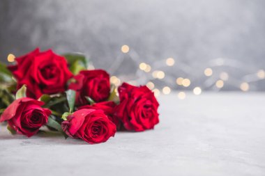 Açık arkaplanda güzel kırmızı güller olan kompozisyon, metin için boşluk. Sevgililer Günü kutlaması