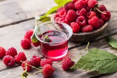 Ahududu alkollü shot, ahşap arka planda renkli likör bardakları.