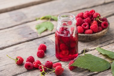 Ahududu likörü ve yapraklı taze meyveler.