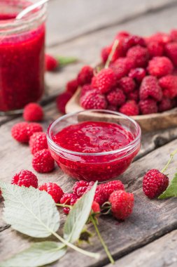 Bir kavanoz ahududu reçeli ve yapraklı taze böğürtlen. Tatlı tatlı