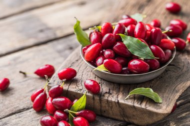 Ahşap bir arka planda, tabakta bir köpek ahşabı. Yaz hasadını topluyorum. Kırmızı çilek.