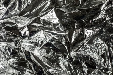 Alüminyum folyonun kapağı buruşmuş. Gümüş folyo dokusu arka planı. Soyut metalik kağıt deseni.