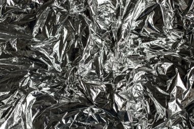 Alüminyum folyonun kapağı buruşmuş. Gümüş folyo dokusu arka planı. Soyut metalik kağıt deseni.