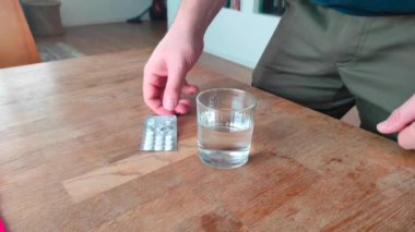 Adam bardaktan suyla hap içiyor. Antidepresan..