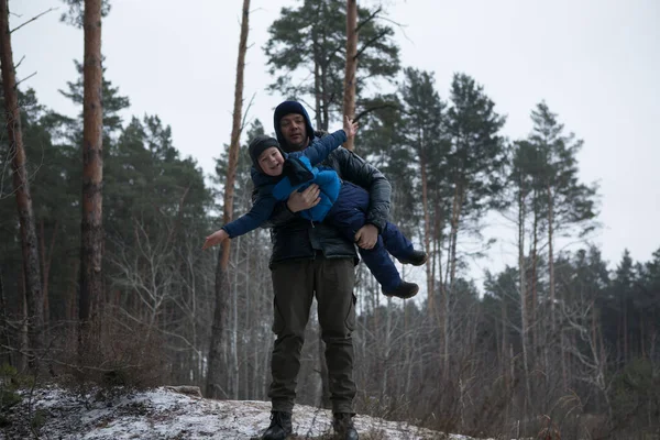 晴れた冬の森の中で屋外で散歩して幸せな家族 クリスマス休暇 父と息子が一緒に遊ぶ — ストック写真
