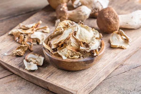 Boletus kurumuş mantar seti, eski, siyah ahşap masa arka planında.