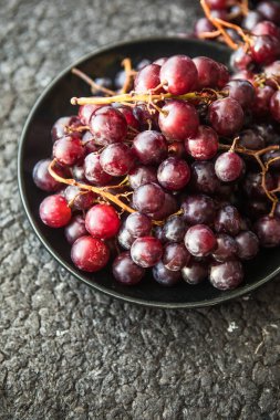 Eski siyah ahşap masadaki kırmızı üzümler. Sonbahar kornucopia sembolü, üst görünüm