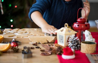Küçük tatlı çocuk Noel kurabiyelerini yeni yıl mutfağında yapıyor..